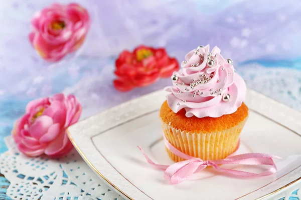 Leckere Cupcake auf Teller, auf hellem Hintergrund — Stockfoto