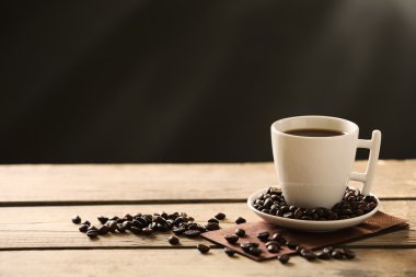 Fincan kahve ve kahve taneleri gri arka plan üzerinde ahşap tablo