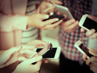 Birçok el cep telefonlarını yakın tutuyor.