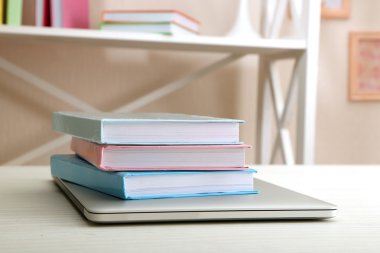 Dizüstü bilgisayar ile kitap yığını