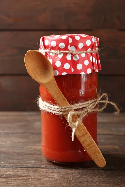 Frasco de vidro de molho de tomate quente, em fundo de madeira — Fotografia de Stock