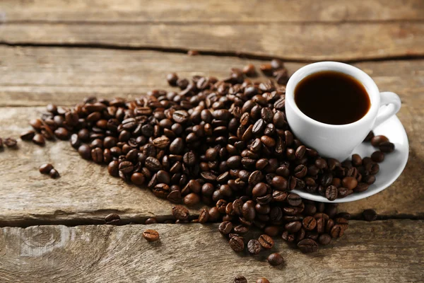 Cup of coffee and coffee grains on wooden background — Stock Photo, Image