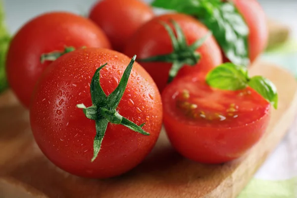 Kerstomaten met basilicum op houten tafel close up — Stockfoto