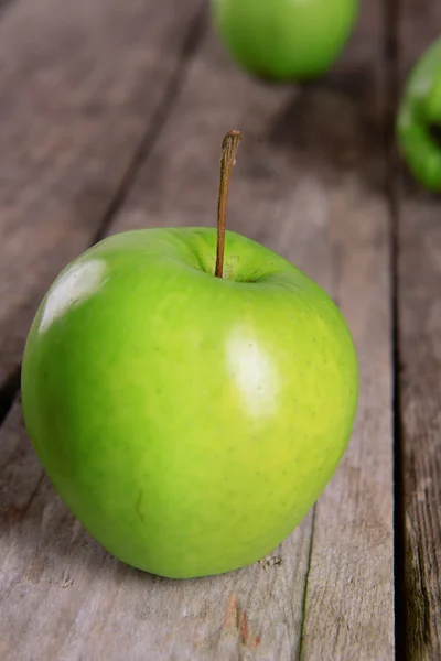 Zralé zelené jablko na dřevěný stůl zblízka — Stock fotografie