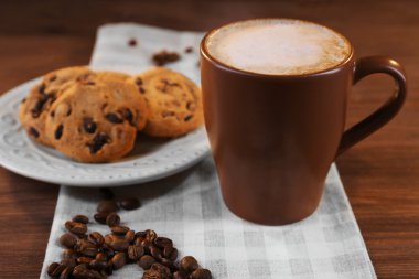 Kahve kavrulmuş kahve çekirdeği etrafında ve bisküvi pamuk peçete ahşap arka plan üzerinde üzerinde