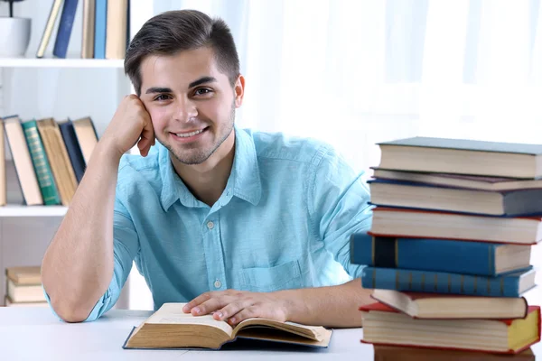 Joven leyendo libro en la mesa — Foto de Stock