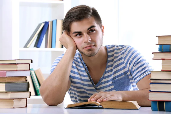 Joven leyendo libro en la mesa — Foto de Stock