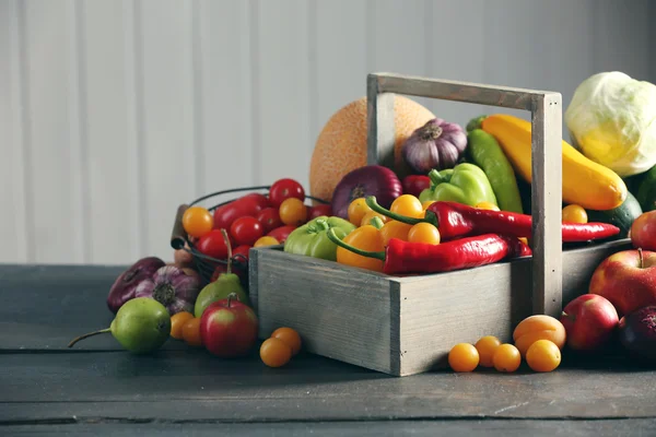 Oogsten van verse groenten en fruit op houten ondergrond — Stockfoto
