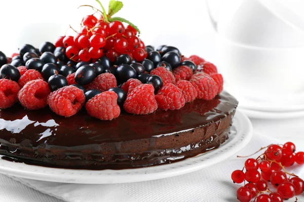 Lahodný čokoládový dort s letními plody na dřevěný stůl, detail — Stock fotografie