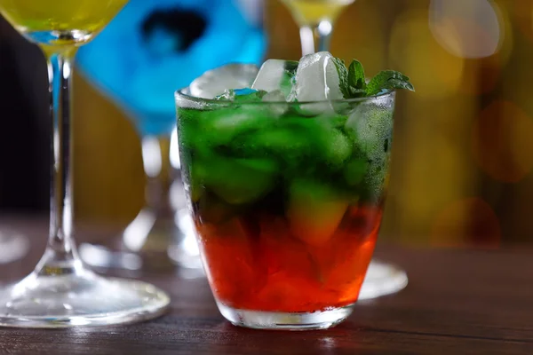 Vasos de cócteles con hielo sobre fondo de luces borrosas —  Fotos de Stock