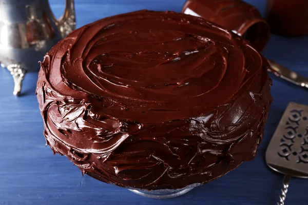 Delicioso pastel con glaseado de chocolate líquido en la mesa de madera azul — Foto de Stock