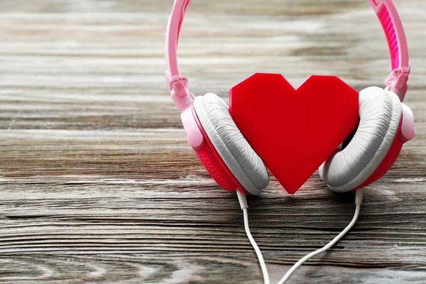 Pink headphones with rosy heart — Stock Photo, Image