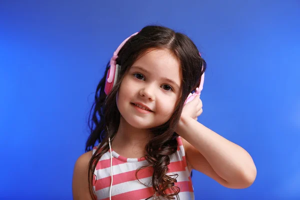 Pembe kulaklık ile çekici küçük kız — Stok fotoğraf
