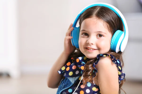 Smiling little girl listening music — Stock Photo, Image