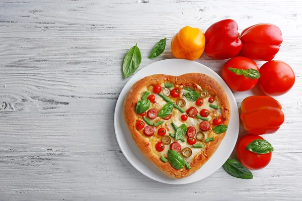 Deliciosa pizza en forma de corazón con verduras sobre fondo de madera — Foto de Stock