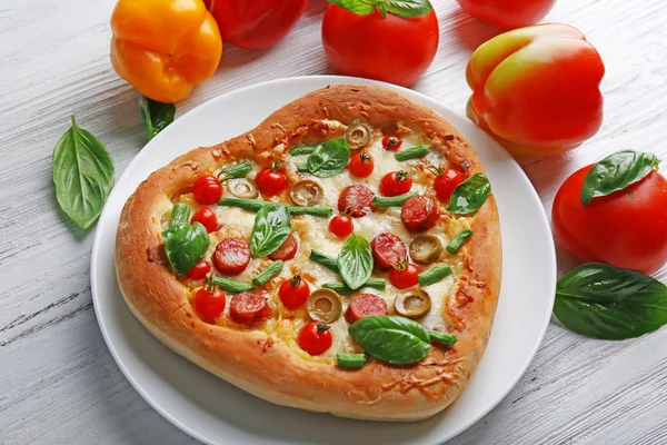 Serce pyszne pizza z warzywami na drewniane tła, z bliska — Zdjęcie stockowe