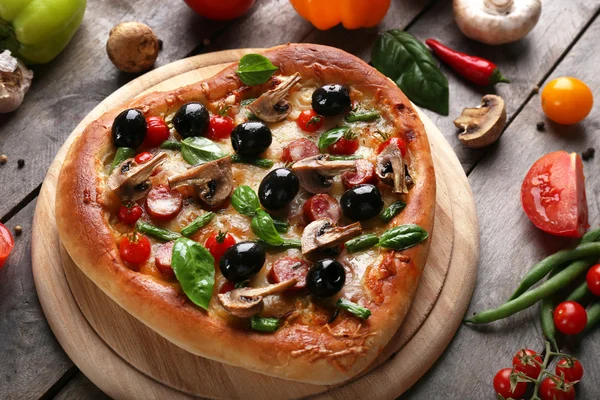 Läckra hjärtformade pizza med grönsaker på trä bakgrund, närbild — Stockfoto