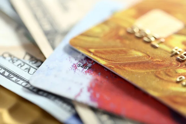 Кредитні картки та долари на золотому фоні — стокове фото