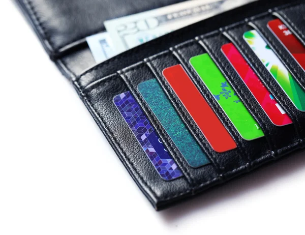 A színes hitelkártya és a pénzt a fehér háttér, fekete bőrtok közelről — Stock Fotó