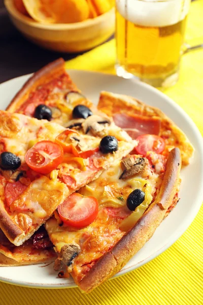 Sliced pizza served with beer on wooden table — Stock Photo, Image