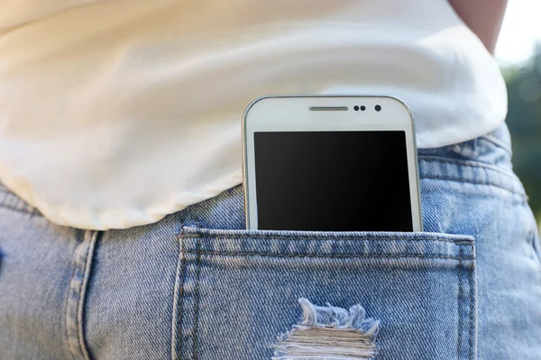 Vit smart mobiltelefon i jeans ficka — Stockfoto