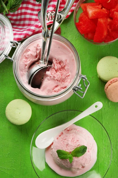 Helado de sandía en frasco de vidrio y en plato, sobre fondo de madera de color — Foto de Stock