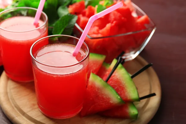 Koude watermeloen dranken in glazen, op houten tafel achtergrond — Stockfoto