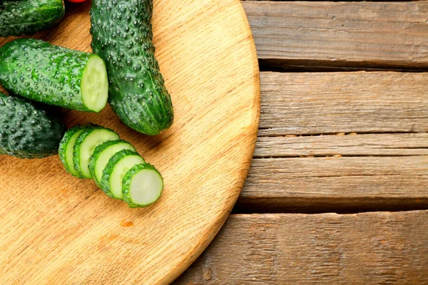 Sliced cucumbers on wooden background — Stock Photo, Image