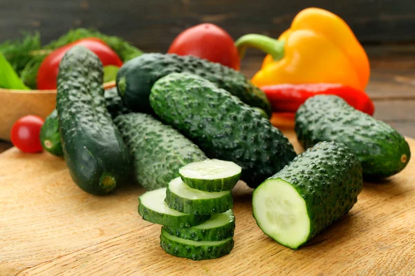 Samenstelling van komkommers, tomaten en paprika cirkels op houten achtergrond — Stockfoto