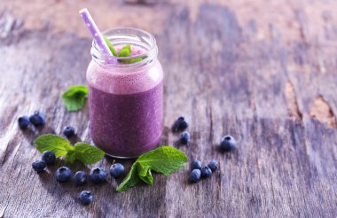 Sağlıklı böğürtlenli yoğurt çukurluğu-cam nane ve ahşap arka plan üzerinde çilek ile