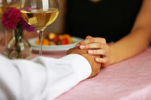 Elegante paar bedrijf handen in het restaurant — Stockfoto