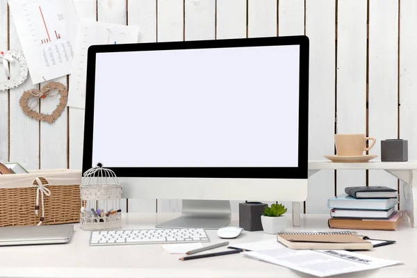 Modern computer on decorated table against wooden wall — Stock Photo, Image