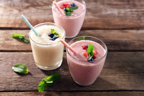 Fresh strawberry and milk yogurts with berries on wooden background — Stock Photo, Image