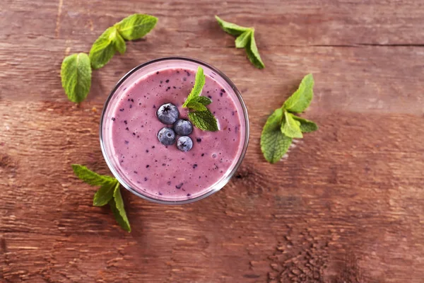 Frischer Blaubeerjoghurt mit Beeren und Minze auf Holzgrund dekoriert — Stockfoto