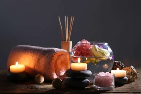 Hermosa composición de spa con tiernas flores rosadas en la mesa de madera en la oscuridad — Foto de Stock