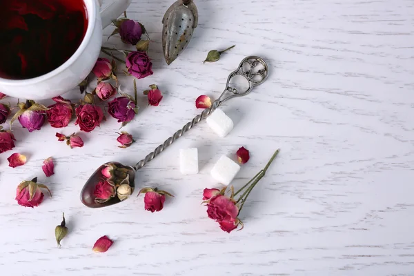 Herbata i herbata róża kwiaty na stole zbliżenie — Zdjęcie stockowe