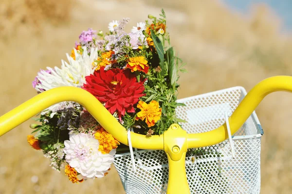 Cykel med bukett blommor i korg — Stockfoto