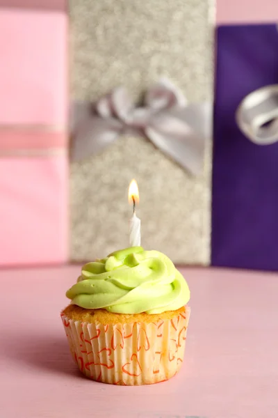 Tasty cupcake with candle on pink table — Stock Photo, Image