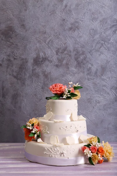 Tarta de boda blanca decorada con flores sobre fondo gris — Foto de Stock