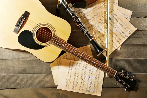 어쿠스틱 기타, 소프라노 색소폰, 바이올린, 플 룻과 참고 시트 나무 배경 — 스톡 사진
