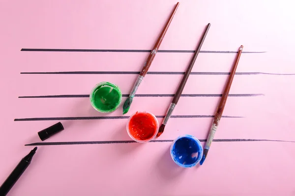 Creative music notes made of colourful paints on pink background — Stock Photo, Image