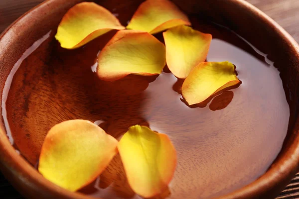 Pétalos de rosa naranja en un tazón de agua, primer plano —  Fotos de Stock