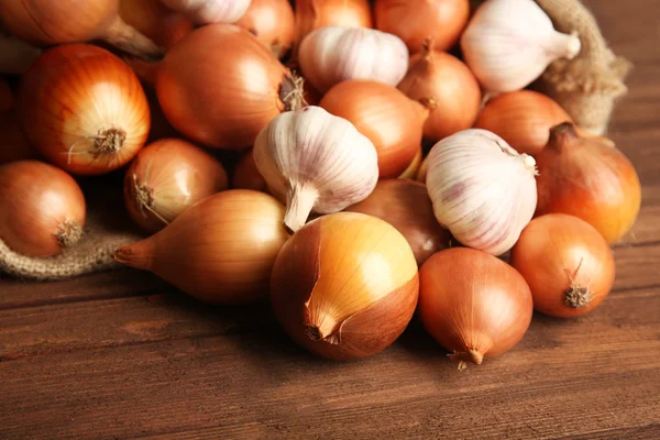 Sacos espalhados com cebola fresca e alho — Fotografia de Stock