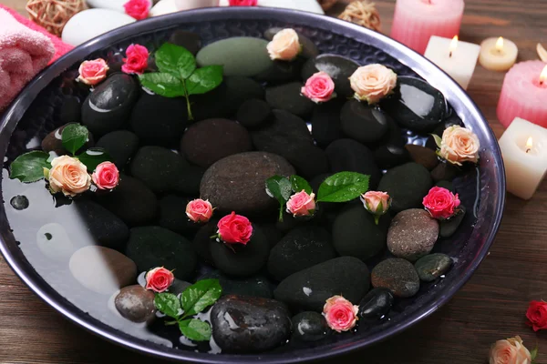 Spa composition of candles, flowers and stones in water