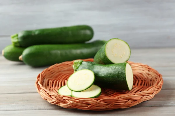 Fresh zucchini on wicker mat — Stock Photo, Image