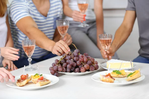 Friends with glasses of wine and snacks — Stock Photo, Image
