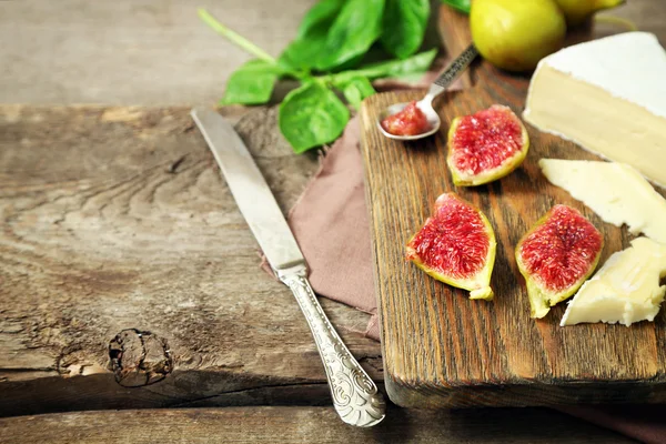 Ripe figs and cheese on cutting board — Stock Photo, Image