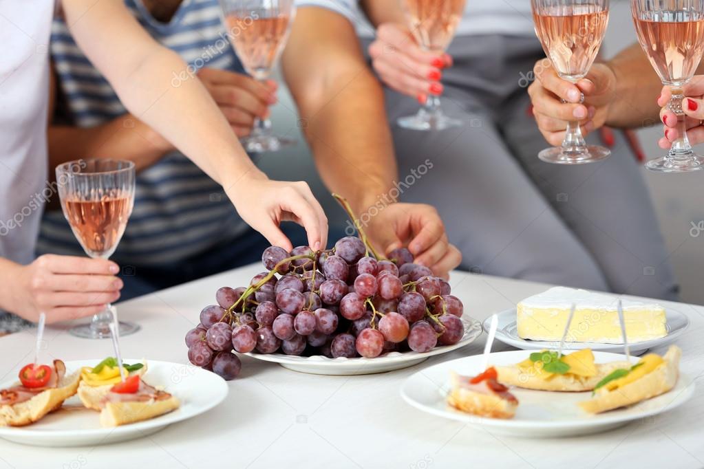 Friends with glasses of wine and snacks