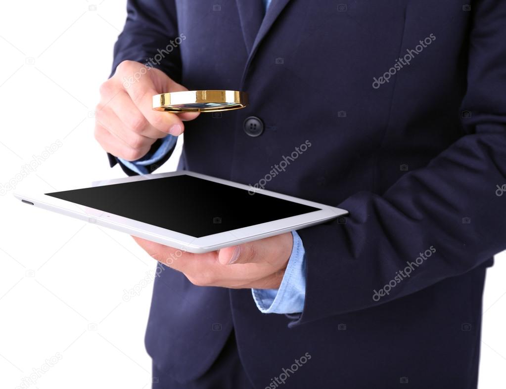 Businessman holding magnifying glass and digital tablet