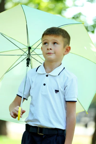Pojke under stora krämig paraply — Stockfoto